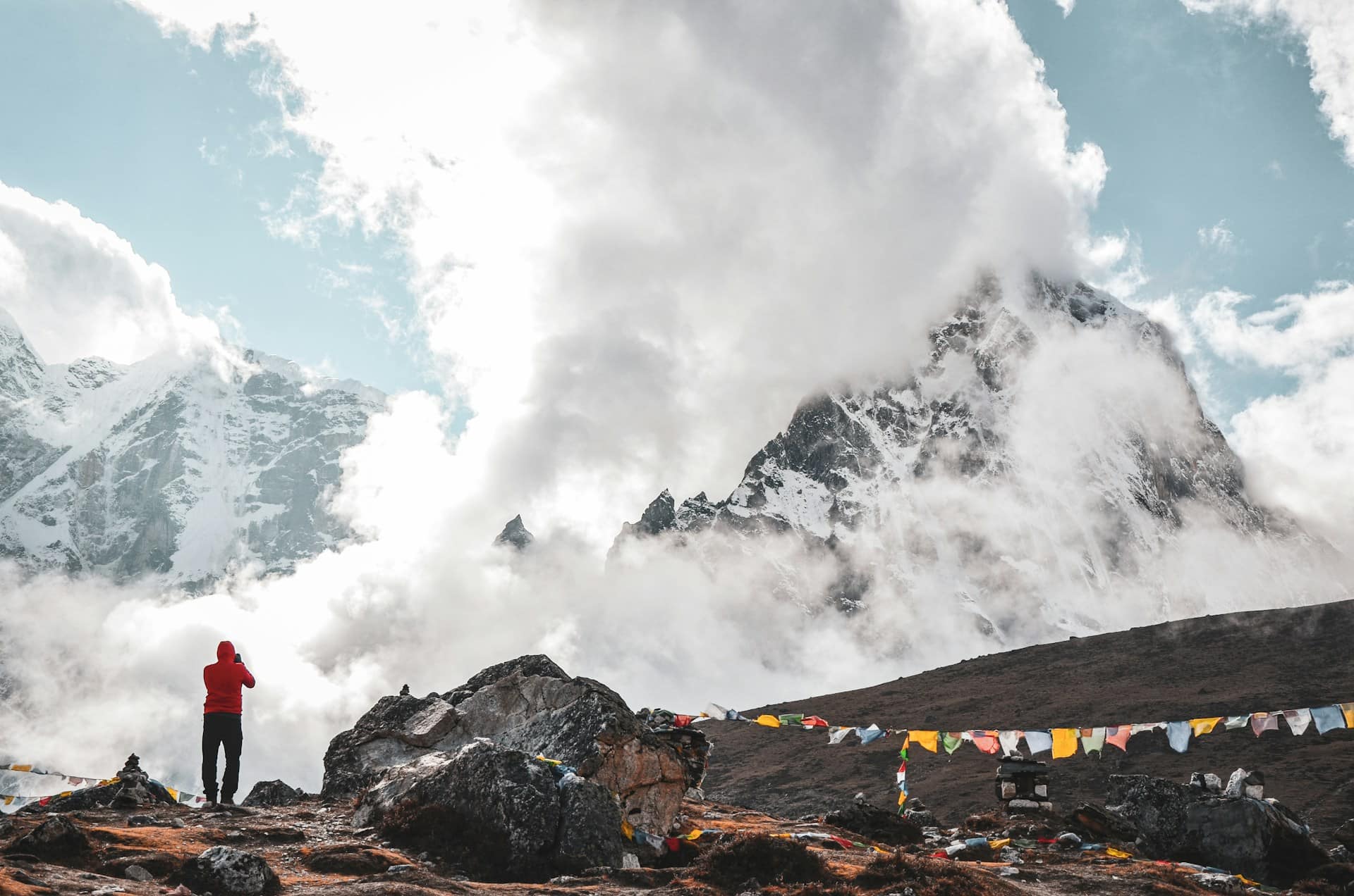 Man Capturing the Beauty of Clouds and Mountains